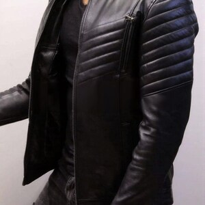 May include: Black leather jacket with a quilted design on the shoulders and upper arms. The jacket has a zipper closure and a small zippered pocket on the chest. The jacket is a classic style.