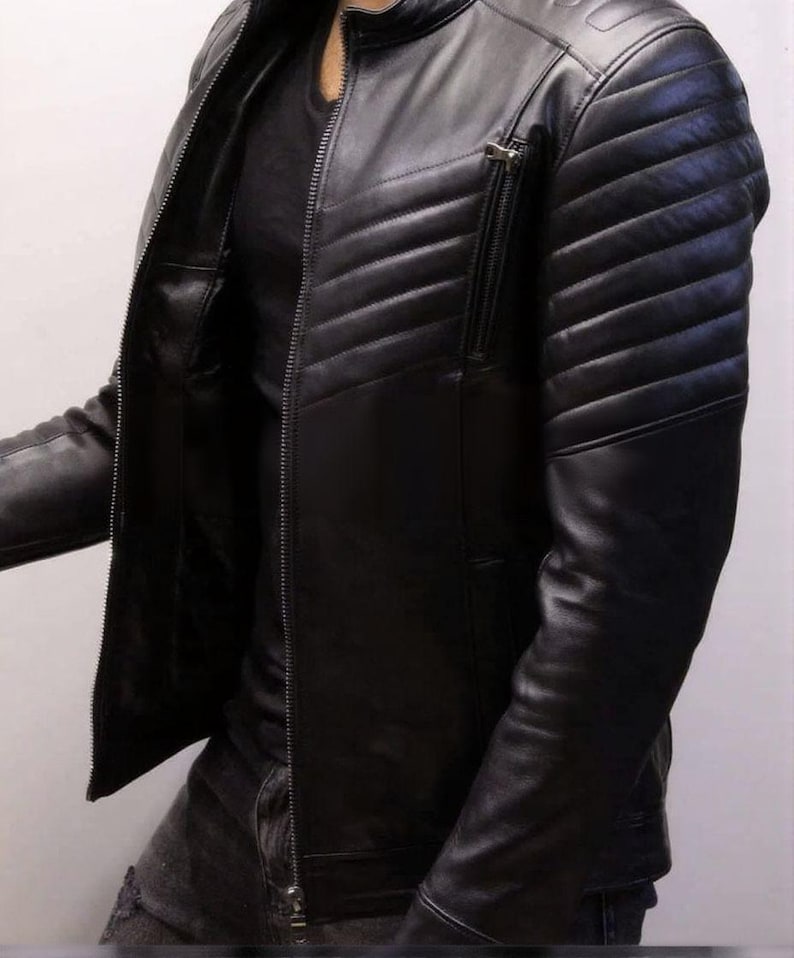 May include: Black leather jacket with a quilted design on the shoulders and upper arms. The jacket has a zipper closure and a small zippered pocket on the chest. The jacket is a classic style.