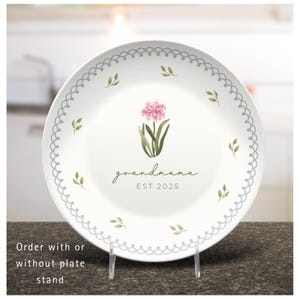 Plate shown on a plastic plate stand.  Can order custom plate with or without stand.  This plate is personalized with 1. Sea pink flower, "grandmama" in script font and "EST 2025" underneath.