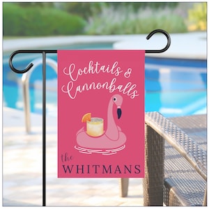 May include: A pink garden flag with the words "Cocktails & Cannonballs" in white script. A flamingo float with a cocktail graphic is centered on the flag. The family name "the WHITMANS" is printed in a navy blue font at the bottom.