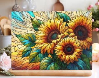 Peut inclure: Un tableau décoratif rectangulaire avec une image de tournesols de style vitrail. Les tournesols ont des pétales jaunes et des centres brun foncé, entourés de feuilles vertes. Le fond présente un motif de mosaïque avec des nuances de jaune, d'orange et de bleu.