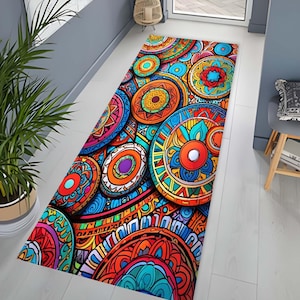 Op de afbeelding: Een kleurrijk vloerkleed met een mandala-ontwerp. Het vloerkleed heeft een verscheidenheid aan kleuren, waaronder rood, oranje, geel, groen, blauw en paars. Het vloerkleed is gemaakt van een zacht, duurzaam materiaal en is perfect om een ​​bohemien touch aan elke kamer toe te voegen.
