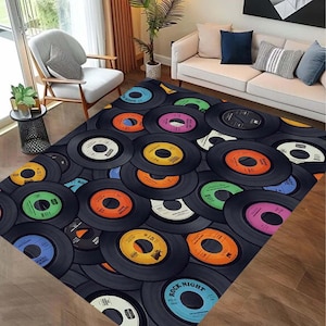 Op de afbeelding: Een kleurrijk tapijt met een ontwerp van vintage vinylplaten. De platen zijn in een cirkelvormig patroon gerangschikt en hebben verschillende kleuren, waaronder rood, geel, blauw, groen en oranje. Het tapijt heeft een zwarte achtergrond en de woorden "Rock Night" zijn in wit op een van de platen gedrukt.