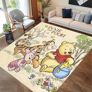 Può includere: Un tappeto rettangolare con Winnie the Pooh e i suoi amici. Il tappeto ha uno sfondo beige con illustrazioni di Pooh, Tigro e Pimpi. Le parole "Winnie the Pooh" sono stampate sul tappeto. Il tappeto è circondato da un pavimento in legno.