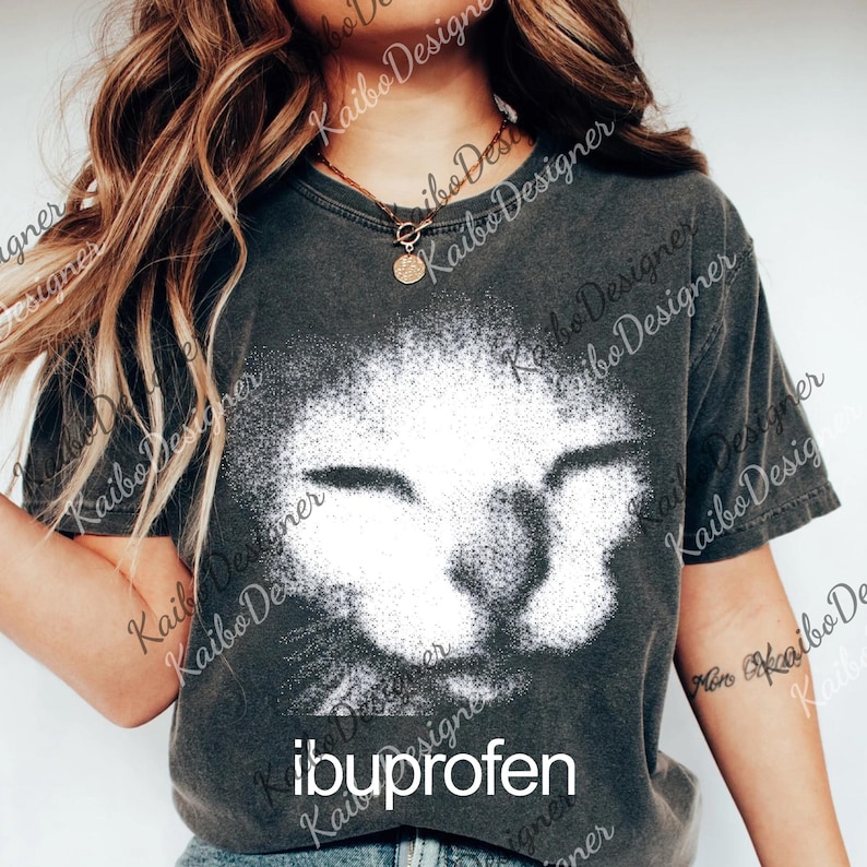 A woman wearing a gray t-shirt with a cat image printed on it, posing against a white background.