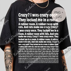 May include: Black t-shirt featuring the white text "Crazy? I was crazy once. They locked me in a room." repeated across the design. The shirt has a crew neck and short sleeves. A casual, statement piece.