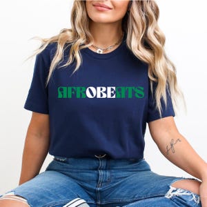 May include: A navy blue t-shirt with the text "AFROBEATS" in green, white, and black letters.