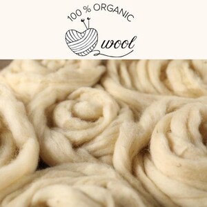 May include: Close-up of cream-coloured organic wool fibres, tightly curled and arranged in a swirling pattern. The image includes the text "100% ORGANIC wool" above the wool. The wool appears soft and fluffy, ideal for crafting projects.