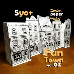 May include: A black and white paper craft set featuring a miniature town with buildings labeled "Shoe Repair Shop", "Pizza King", "Fire Station", "Antique Shop", and "Pet Shop". The set is labeled "Fun Town vol 02" and "Timeless paper Project".