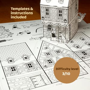 May include: A paper craft kit featuring a black and white printed house template with instructions. The set includes a 3D assembled house model, a person with a broom, a dog, and various Christmas-themed cutouts on flat sheets.