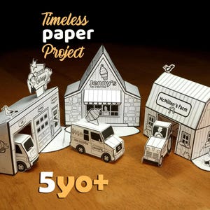 Può includere: Un progetto di artigianato in carta in bianco e nero con edifici in miniatura: un garage, una gelateria e una fattoria. Il testo "Timeless paper Project" e "5yo+" sono visibili. Include un camioncino dei gelati e un trattore di carta.