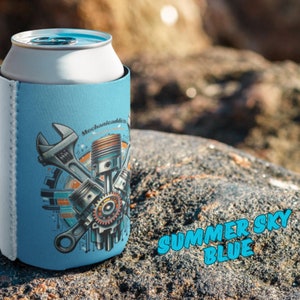 May include: A blue and white can cooler with a design of wrenches and pistons. The text "Mechanically Cool" is printed on the cooler. The words "Summer Sky Blue" are printed in a large font on a rock below the cooler.
