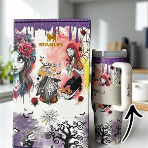 Puede incluir: Un vaso Stanley H2.0 Flowstate de 1,18 L y su caja a juego con un dise&ntilde;o espeluznante con personajes, rosas y telara&ntilde;as. La caja y el vaso tienen una combinaci&oacute;n de colores p&uacute;rpura y blanco con el texto "Design 1" y "UnitedCrafty".