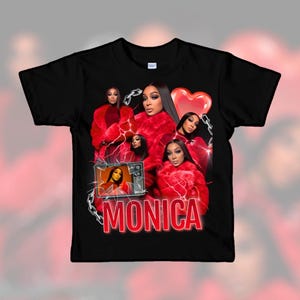 May include: Black t-shirt featuring a collage of images of a woman in a red fur coat, a red heart, and the name "MONICA" in red. The design includes a vintage television and chain details.