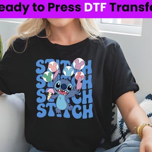 Puede incluir: Camiseta negra con un personaje azul Stitch sosteniendo un cono de helado. La camiseta tiene la palabra "Stitch" repetida en una fuente retro.