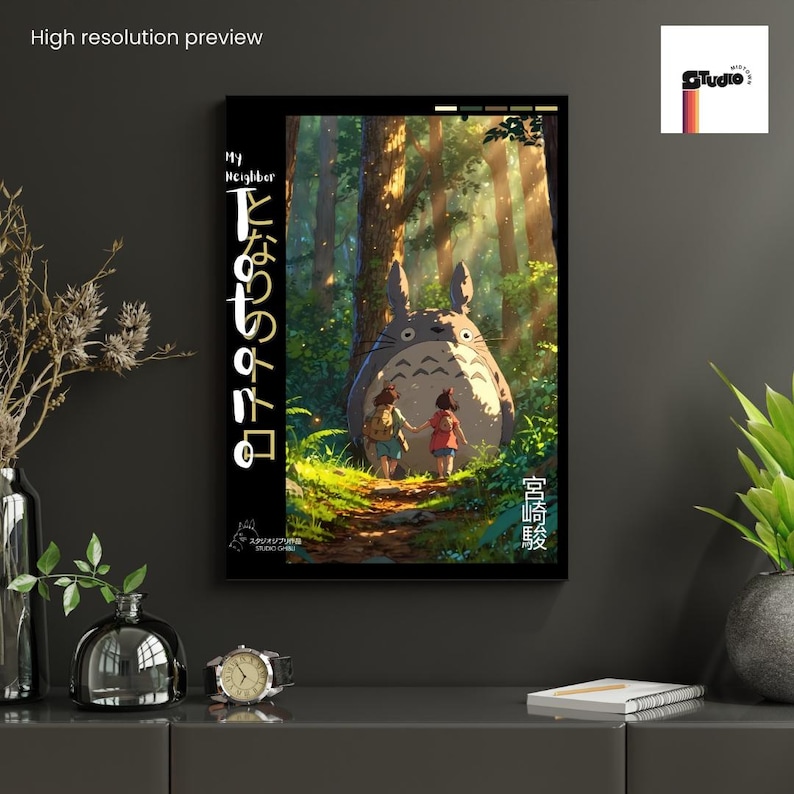 May include: A framed art print featuring a scene from "My Neighbor Totoro." The artwork depicts two children walking on a forest path towards a large, furry creature. The print has Japanese text on the left side and is set against a dark background.