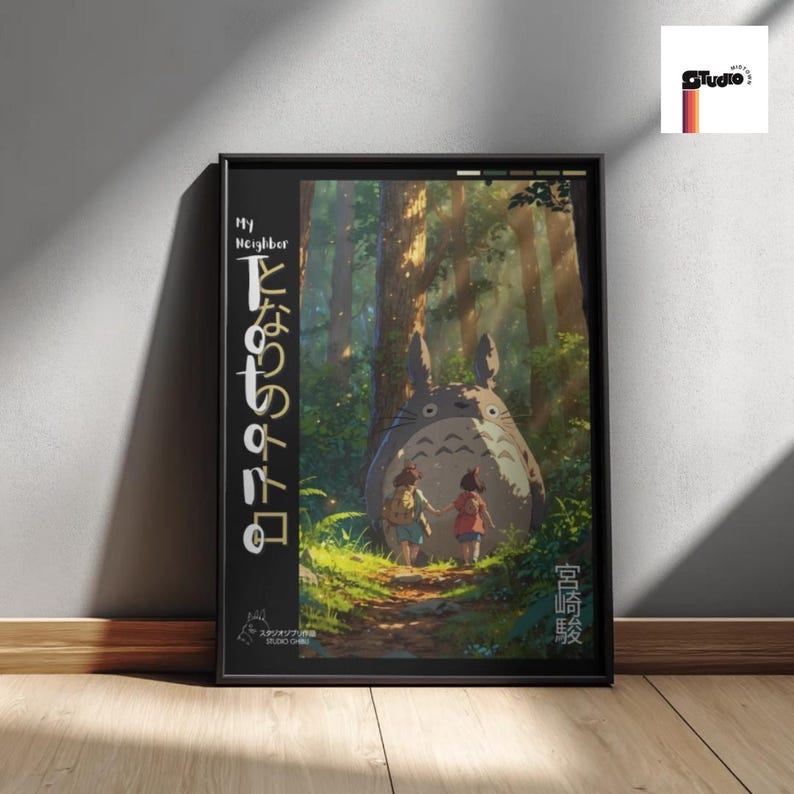 May include: Framed art print featuring a scene from "My Neighbor Totoro." The artwork depicts Totoro with two children in a forest setting. Japanese text is visible on the left and right sides of the frame. The print is in a black frame.