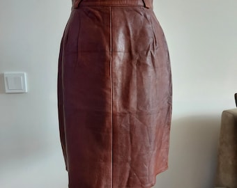 May include: A brown leather skirt with a high waist and a straight silhouette.