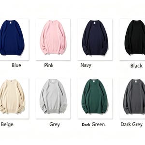 May include: A collection of crew neck sweatshirts in various colors, including white, blue, pink, navy, black, red, green, beige, grey, dark green, dark grey, and purple. Each sweatshirt is displayed on a white background.