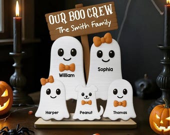 Può includere: Decorazione di Halloween in legno raffigurante una famiglia di fantasmi con la scritta "OUR BOO CREW The Smith Family". Ogni fantasma ha un nome, un papillon o un fiocco e una faccia sorridente. La decorazione è su una base di legno.