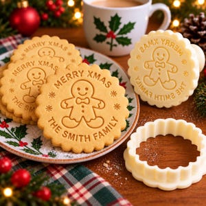 May include: A round cookie stamp with a scalloped edge, featuring an embossed gingerbread man, the text MERRY XMAS, and the custom text THE SMITH FAMILY. The white plastic tool is shown alongside stamped cookies on a plate.