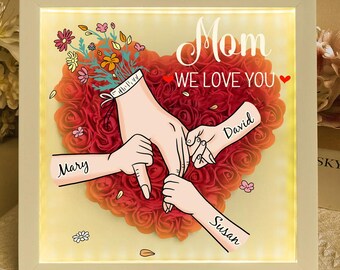 Può includere: Una cornice bianca con un cuore illuminato fatto di rose rosse. Il cuore ha le parole "Mamma Ti amiamo" in alto e i nomi "Mary", "David" e "Susan" sui lati.