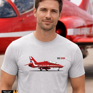 May include: A grey t-shirt with a red BAE Hawk jet graphic, the text "BAE HAWK" and "Royal Air Force". The shirt is from the "Big Cat Store".