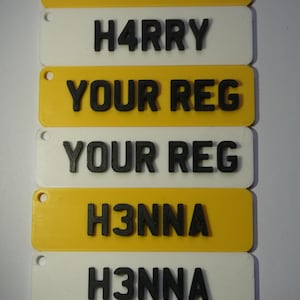 Peut inclure: Six plaques rectangulaires empilées, alternant jaune et blanc, avec des lettres noires. La plaque supérieure indique "B055", suivie de "H4RRY", "YOUR REG", "YOUR REG", "H3NNA" et "H3NNA".