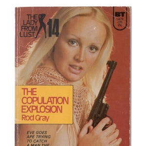 May include: A vintage paperback book cover with a woman holding a gun. The cover is orange and yellow with the title "The Copulation Explosion" by Rod Gray. The book is part of a series called "The Lady From Lust" and is numbered 14.