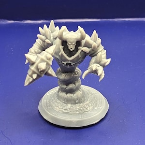 May include: A gray, 3D printed miniature of a demonic creature with horns, spikes, and a swirling base. The creature has a skull-like face and appears to be in a menacing pose.