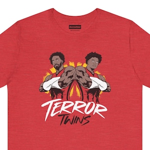 Könnte beinhalten: Rotes T-Shirt mit einem Grafikdruck von zwei Basketballspielern mit dem Text "Terror Twins" in Weiß.