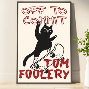 May include: A framed art print featuring a black cat on a skateboard with the words "OFF TO COMMIT TOM FOOLERY" in red. The cat is silhouetted with white stripes on its legs and arms.