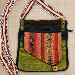 May include: A crossbody bag featuring a lime green woven fabric base with a black zipper closure. An attached front pocket displays vertical stripes in shades of orange, red, and yellow. The long shoulder strap has a matching striped pattern.