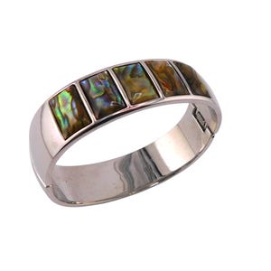 May include: A silver-toned hinged bracelet featuring rectangular abalone shell inlays. The iridescent shells display a mix of green, gold, and brown hues. The bracelet has a polished finish and a secure clasp.