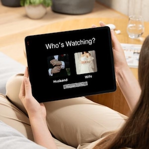 May include: A tablet screen displaying a Who's Watching interface with two profile icons. The left icon shows a person in a dark suit labelled Husband, and the right icon shows a person in a white dress labelled Wife. A Manage Profiles button is below.