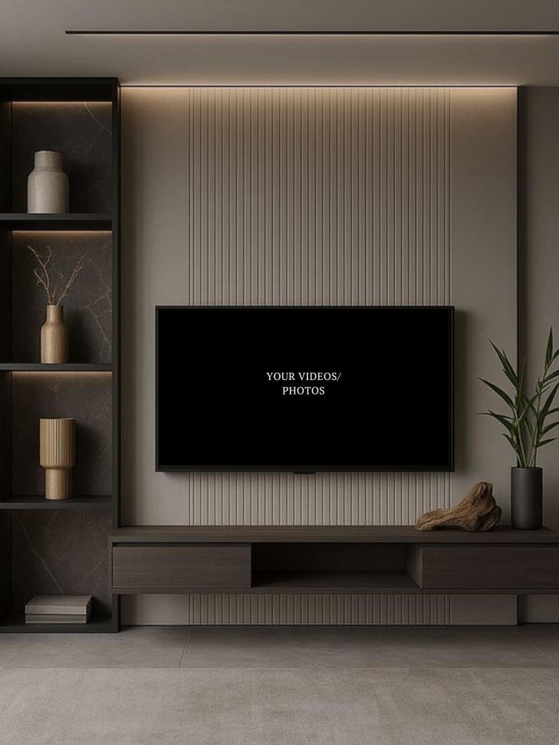 May include: A wall-mounted television with the text YOUR VIDEOS/PHOTOS displayed on the screen, positioned above a dark wood media console. To the left is a tall shelving unit with decorative vases and to the right is a potted green plant.