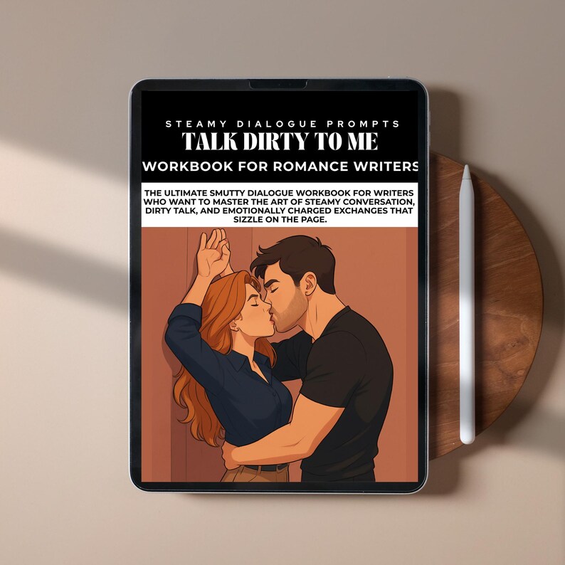 May include: A digital tablet displays the cover of a workbook titled "Talk Dirty to Me: Workbook for Romance Writers." The cover illustration depicts a couple kissing. The tablet is next to a white stylus and rests on a wooden surface.