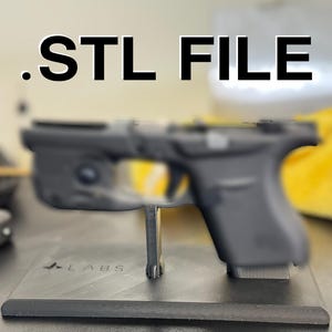 Puede incluir: Un soporte de limpieza imprimible de archivo .STL negro. El soporte está diseñado para sostener un arma de fuego. El texto ".STL FILE" está en la parte superior de la imagen y "PRINTABLE CLEANING STAND" en la parte inferior.