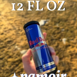 May include: A silver can of Red Bull Energy Drink with a blue and red bull logo. The can is 12 fluid ounces and says "Vitalizes body and mind."