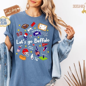 May include: A blue t-shirt with the text "Let's go Buffalo" and various graphics, including a football, helmet, and the number 50. The shirt has rolled-up sleeves and is worn with a denim jacket.