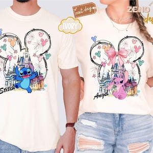 May include: Ivory-colored t-shirts featuring a whimsical design of a castle, fireworks, and cartoon characters Stitch and Angel. The design is framed by a Mickey Mouse head outline with colorful balloons and stars. The names "Stitch" and "Angel" are written below.