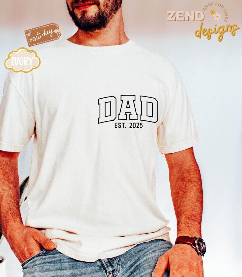 May include: White t-shirt with black text that reads "DAD EST. 2025".