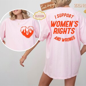 May include: Pink t-shirt with a barbed wire heart with flames on the front and the text "I support women's rights and wrongs" on the back.