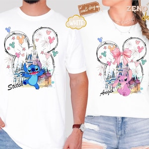 May include: White t-shirts featuring a Disney-themed design. One shirt has a blue Stitch graphic with the word "Stitch", and the other has a pink Angel graphic with the word "Angel". Both shirts have a castle and fireworks.