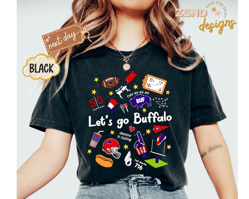 May include: Black t-shirt with a graphic design featuring the text "Let's go Buffalo" and various sports-themed illustrations. Includes a football, helmet, and the number 716. The shirt also has the text "next day" and "BLACK".