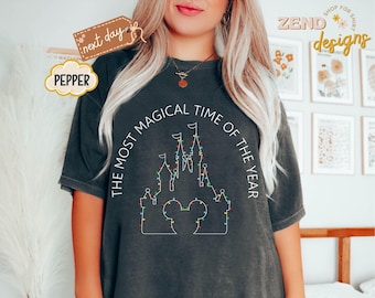 Camiseta Comfort Colors "Es la época más mágica del año" con luces navideñas de Disney, camiseta del Castillo de Disney, camiseta navideña de Mickey, camiseta de regalo de Navidad.