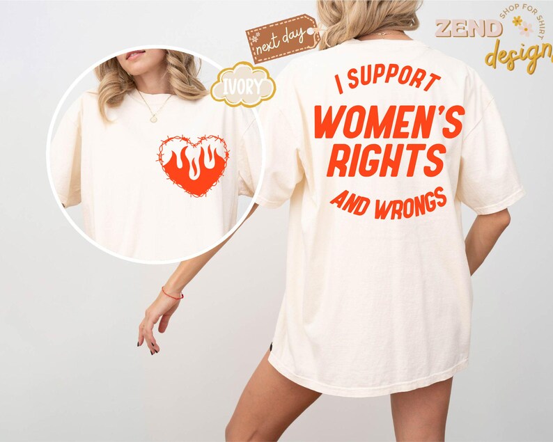 May include: A white t-shirt with the text "I support women's rights and wrongs" printed in orange on the back. The front of the shirt features a red heart with flames inside, surrounded by barbed wire.