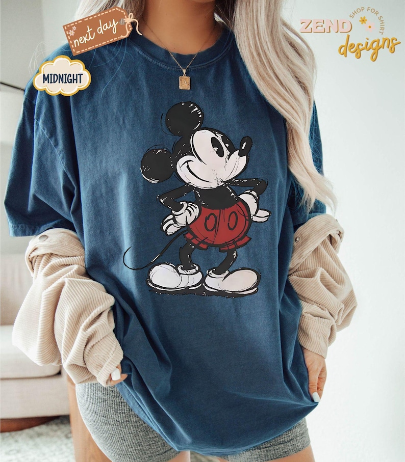 May include: A blue t-shirt with a vintage-style Mickey Mouse graphic. The shirt is oversized and has a relaxed fit.