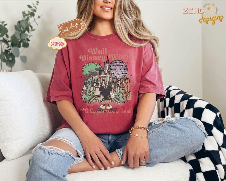 以下が含まれることがあります： ミッキーマウスが描かれたウォルト・ディズニー・ワールドのグラフィックが特徴のクリムゾン色のTシャツ。「Walt Disney World」と「The happiest place in earth」の文字がプリントされています。ゆったりとしたオーバーサイズのフィット感です。