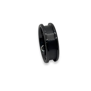 Peut inclure: Une bague noire avec une finition brossée et un bord biseauté.